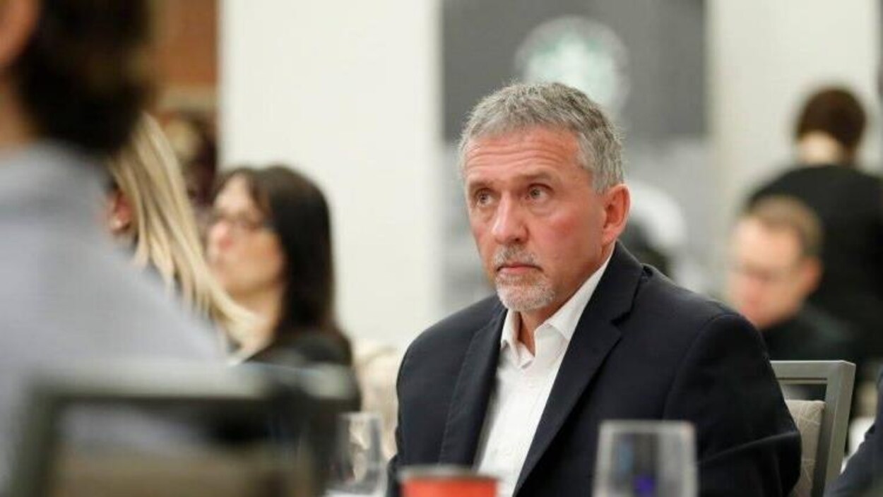 L' homme d'affaires se trouve dans une foule de gens qui assistent à un événement.