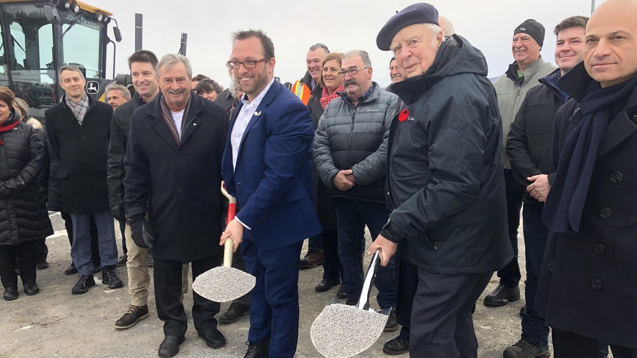 Daniel Côté et Michel Pouliot tiennent chacun une pelle pleine de terre, pendant la cérémonie de lancement des travaux.