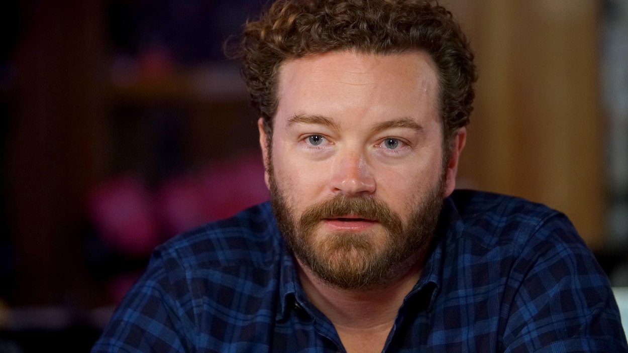 Danny Masterson, assis dans un bar, écoute une question du public.