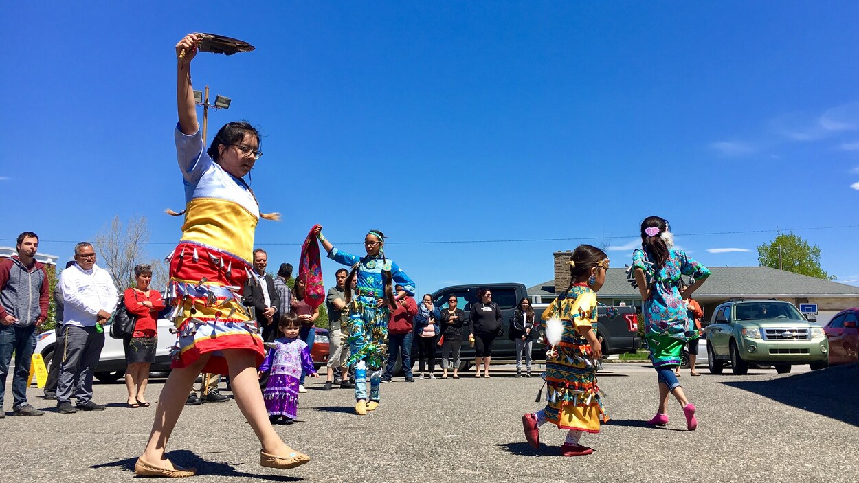 Une jeune femme danse en habit traditionnel autochtone.