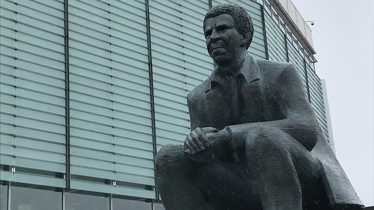 La sculpture montre l'écrivain assis.