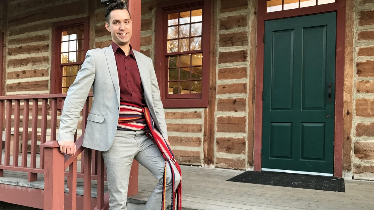 Darrel Nadeau, directeur général du Festival du Voyageur, pose au Fort Gibraltar à Winnipeg avec une ceinture fléchée.