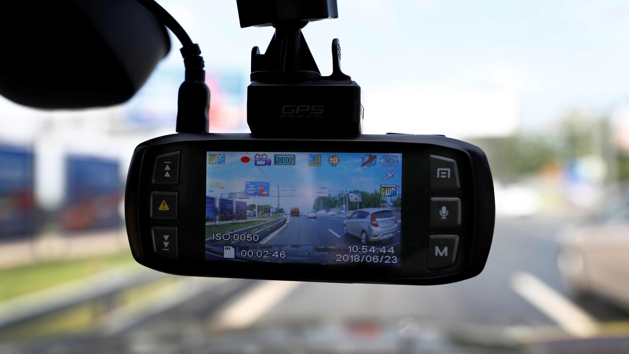 Une caméra accrochée au pare-brise intérieur d'une voiture.