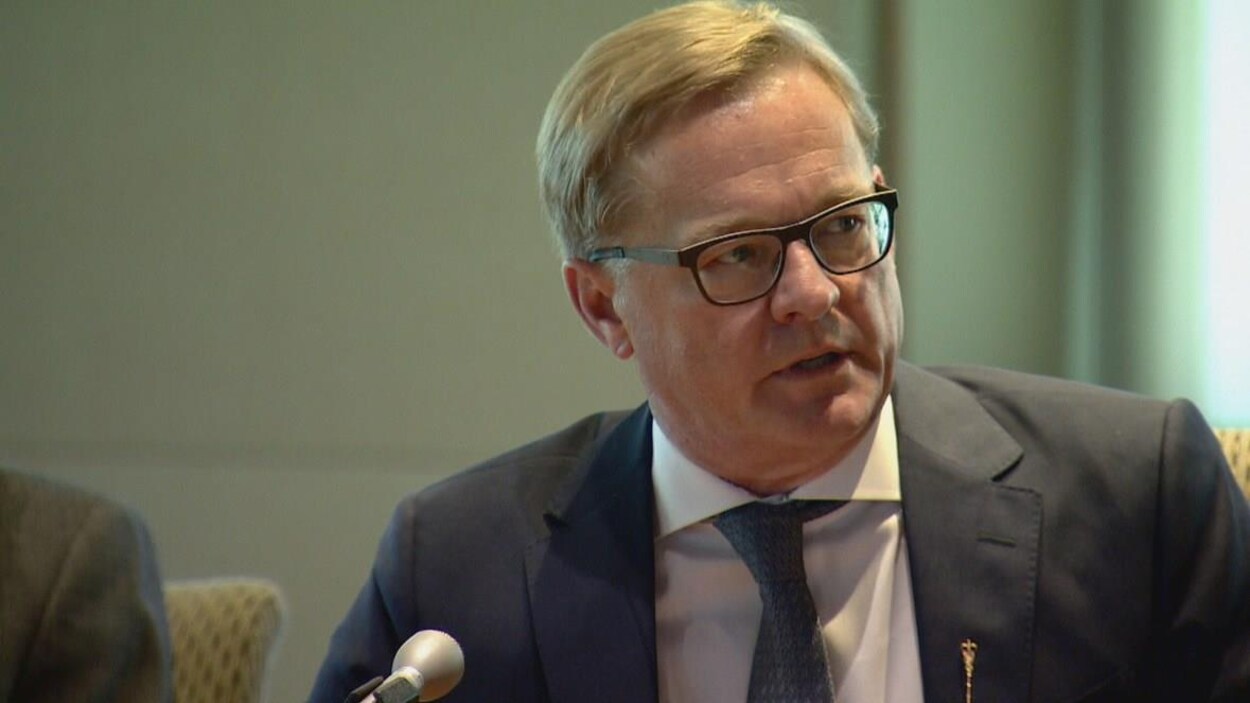 Plan serré de David Eggen assis devant un micro.