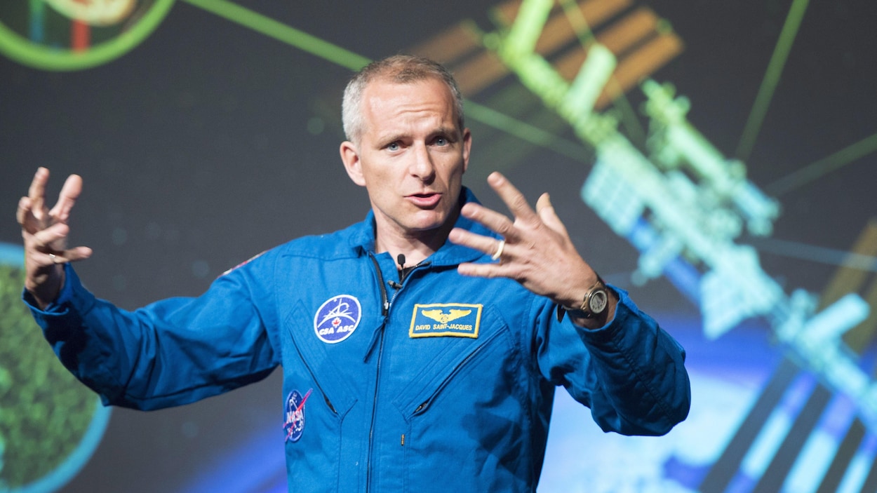 L'astronaute David Saint-Jacques, vêtu de son uniforme à l'effigie de l'Agence spatiale canadienne, donne une conférence qui porte sur son départ vers la Station spatiale internationale. L'astronaute David Saint-Jacques, vêtu de son uniforme à l'effigie de l'Agence spatiale canadienne, donne une conférence qui porte sur son départ vers la Station spatiale internationale.