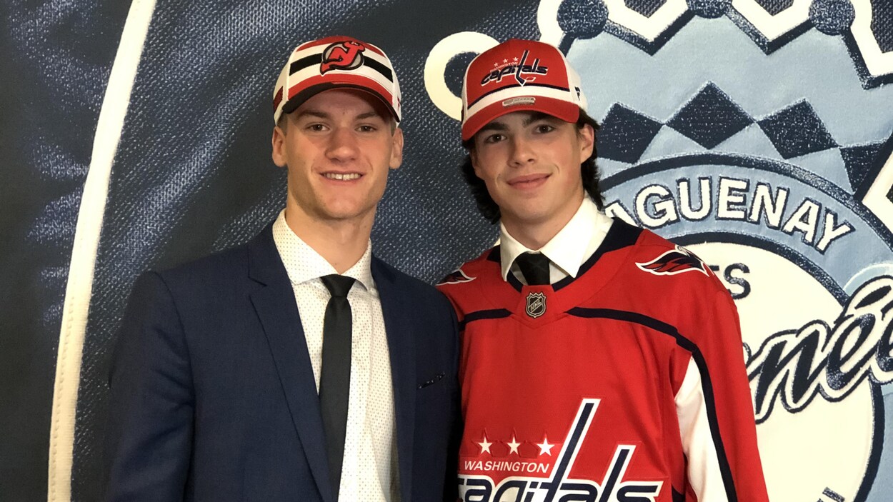 Dawson Mercer et Hendrix Lapierre côte-à-côte devant le sigle des Saguenéens.