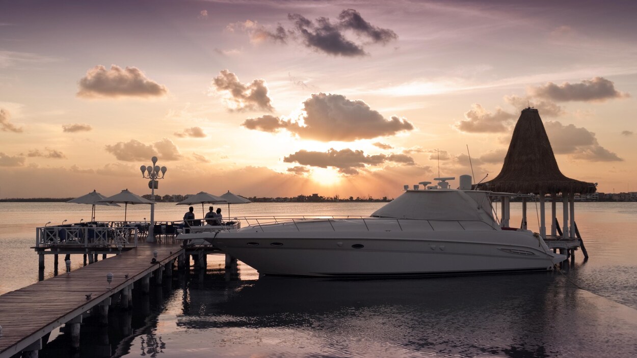 Un luxueux bateau accosté à un quai lors d'un coucher de soleil