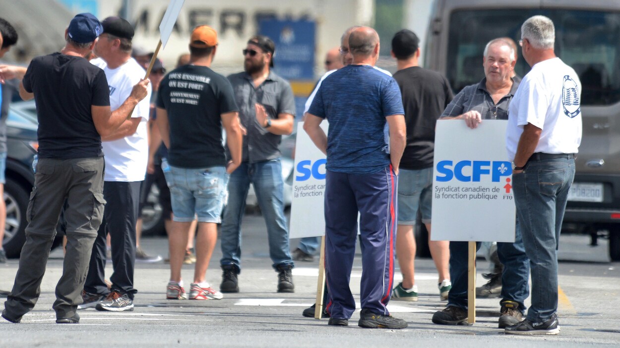 Des hommes discutent en cercle dans le port.