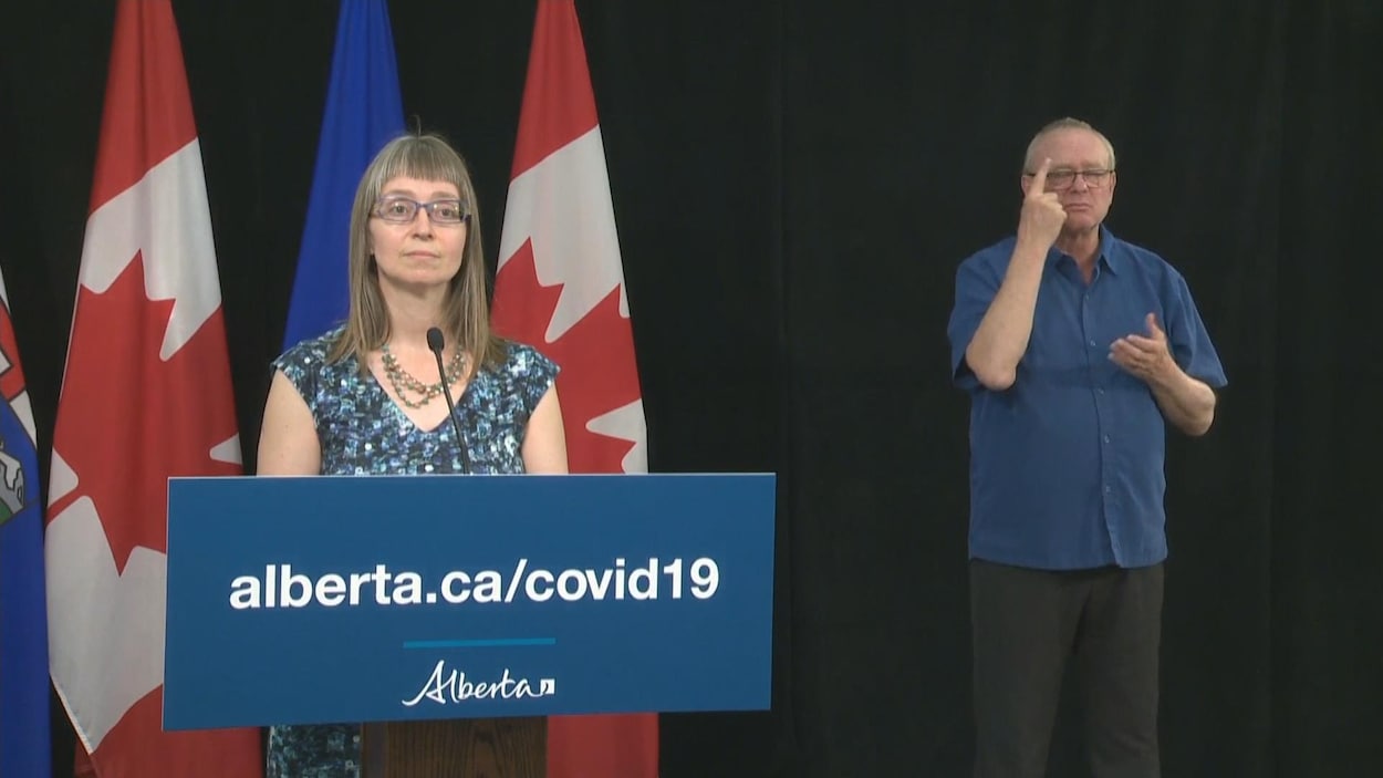Deena Hinshaw au micro accompagné par l'interprète de la langue des signes.