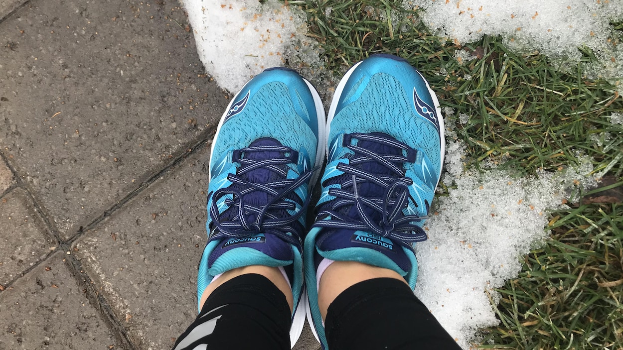 Des chaussures de course dans du gazon enneigé.