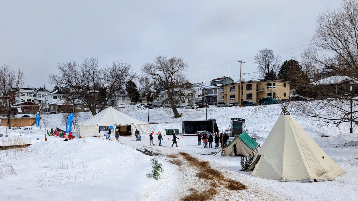 Des tentes et des gens près du lac Saint-Louis à La Tuque.