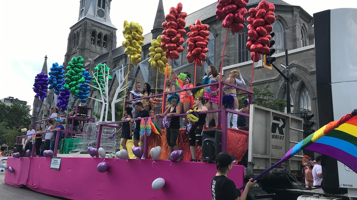 Un char sur lequel des gens dansent entourés de ballons.