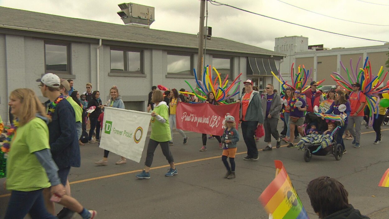 Des personnes qui défilent le long des rues de Regina pendant le défilé de la Fierté.