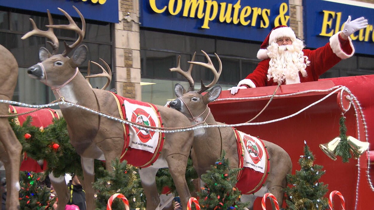 Le père Noël dans son char allégorique salue la foule. Le père Noël dans son char allégorique salue la foule.
