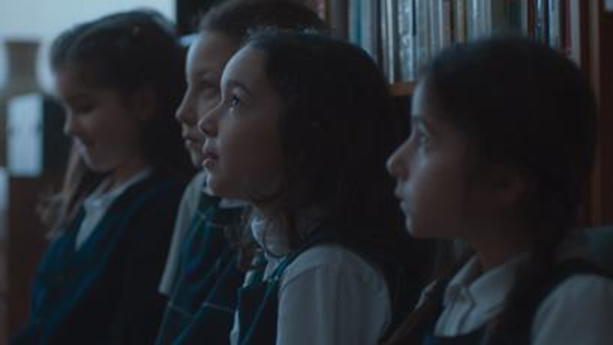 Quatre petites filles portant un uniforme scolaire.