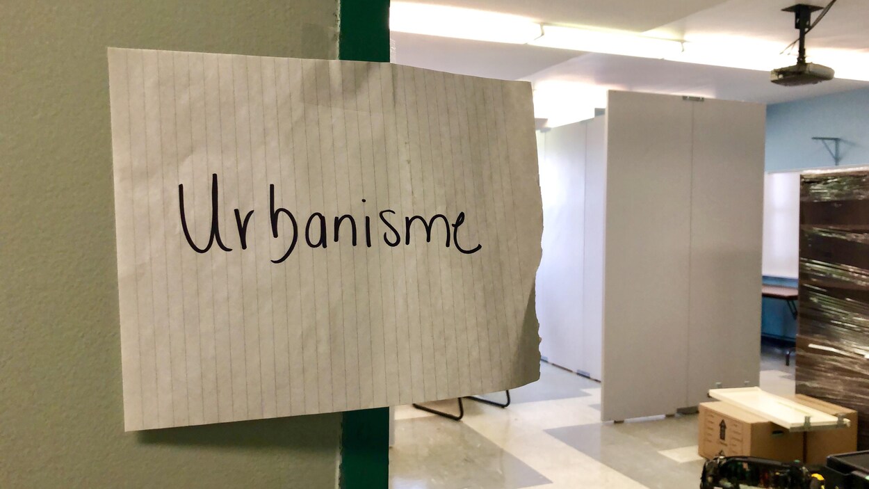 Une feuille papier, collée sur un mur, sur laquelle il est écrit le mot urbanisme