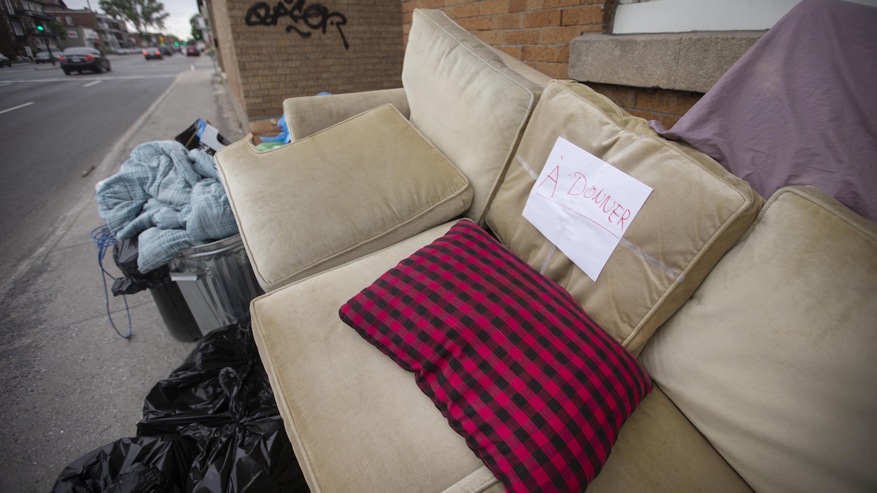 Des meubles à donner empilés sur un trottoir.