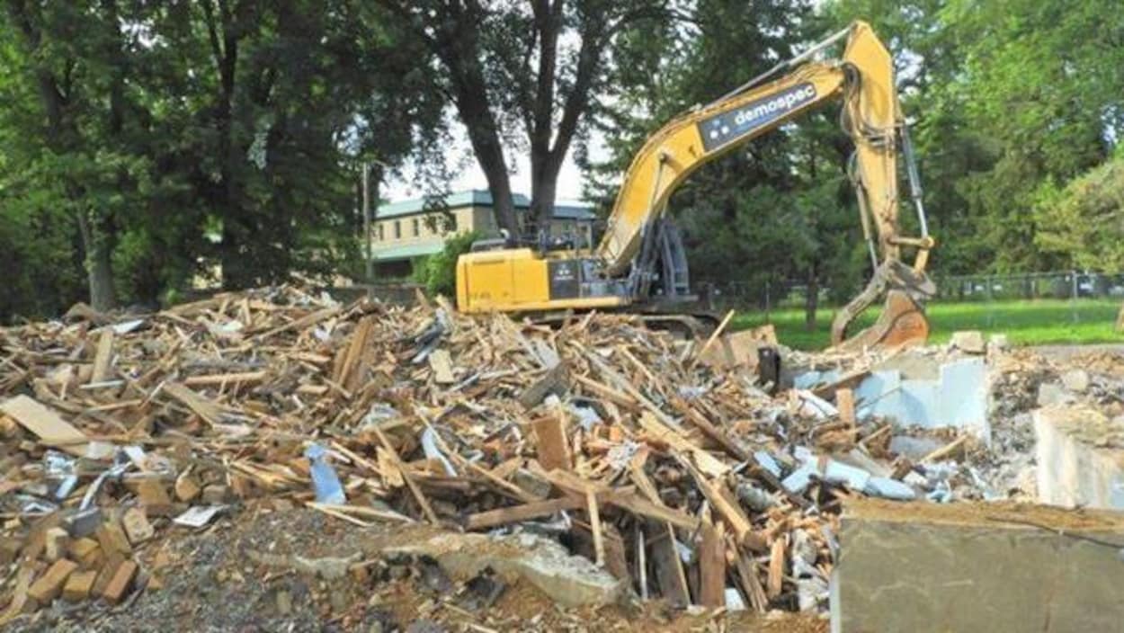Les décombres de la Maison Pelland à côté d'une grue