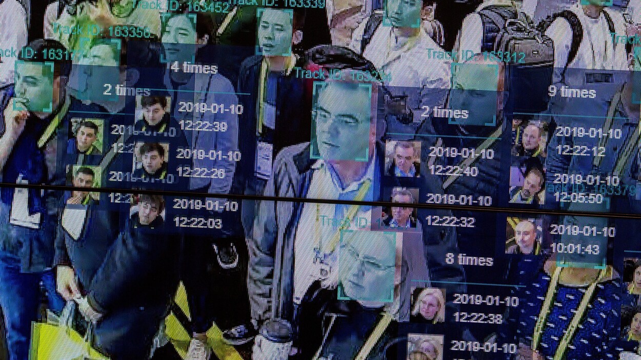 Plusieurs personnes apparaissent sur un écran, le visage encadré par un logiciel de reconnaissance faciale.