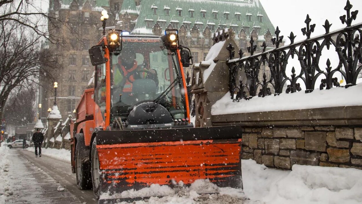 Une déneigeuse sur le trottoir de la rue Wellington, devant le parlement d'Ottawa.