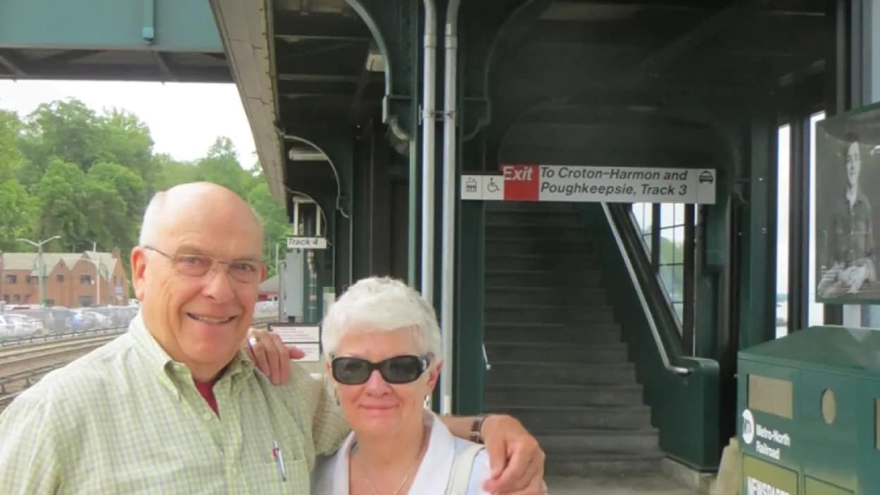 Dennis Anderson et sa femme sont bras dessus bras dessous, sur le quai d'une gare.