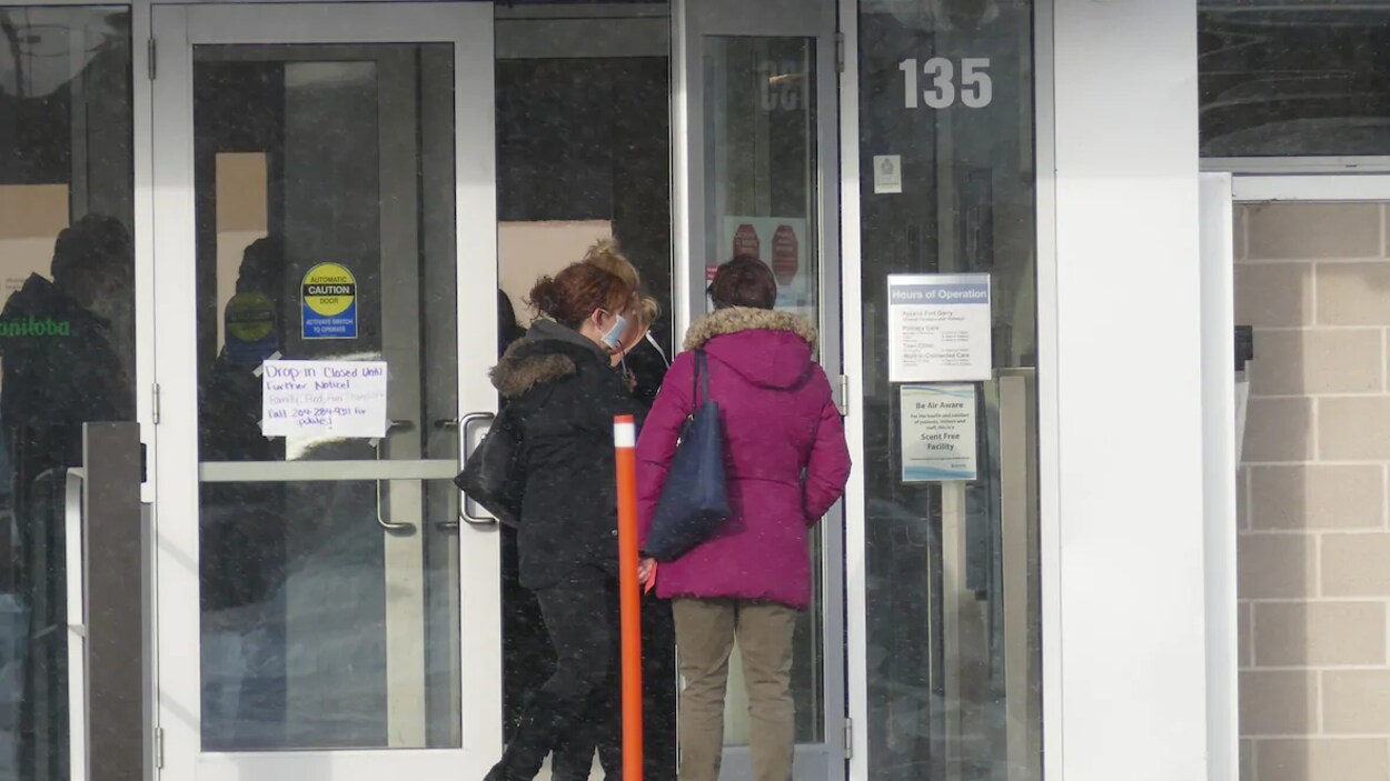 Deux femmes vu de dos entre dans une clinique de dépistage de la COVID-19.