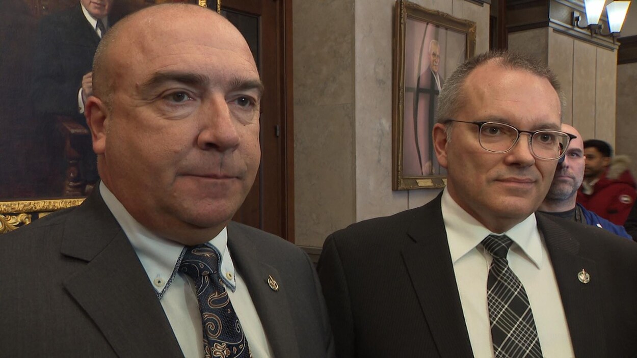 Les deux hommes sont côte à côte.