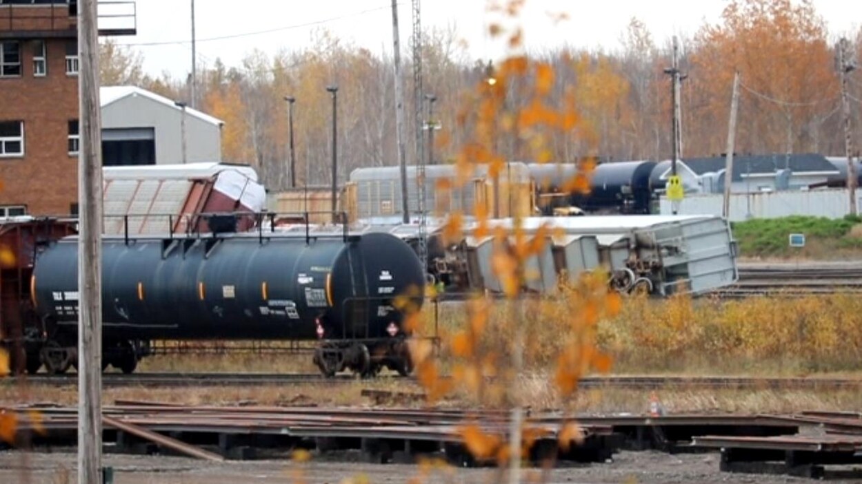 Deux wagons renversés sur les rails.