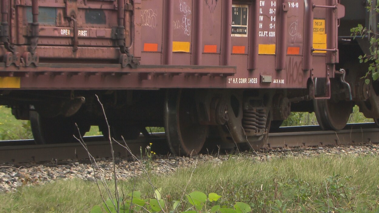 Une roue d'un wagon est sortie des rails du chemin de fer.