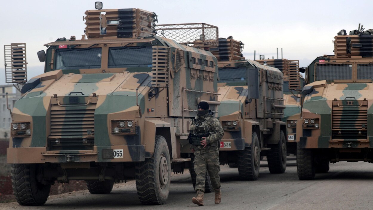 Des véhicules militaires sur une route.