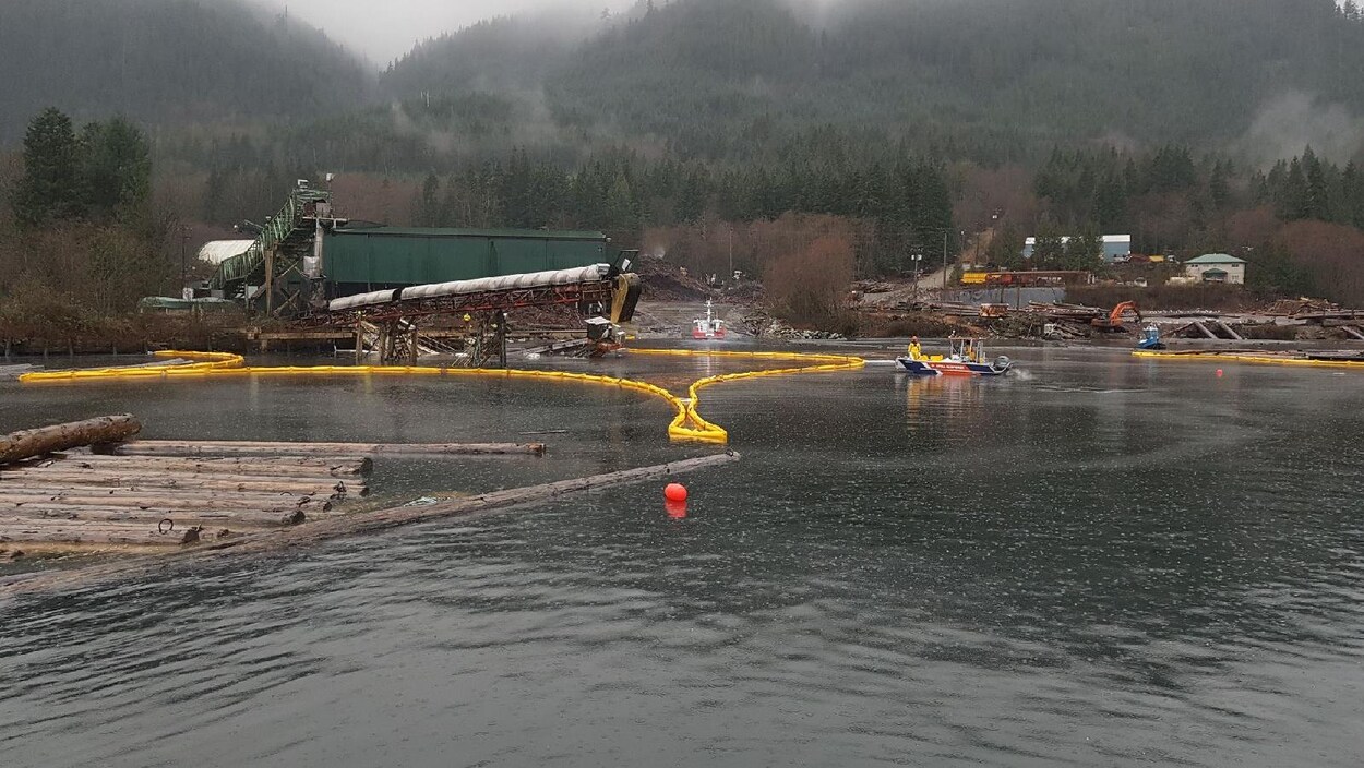 Un déversement diésel entouré d'un barrage jaune sur la surface de l'eau.