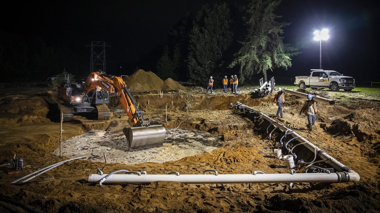 Un chantier avec des travailleurs, de nuit.