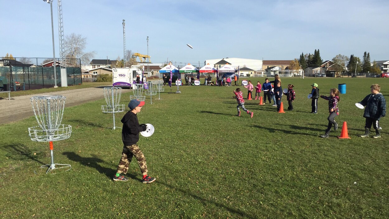 Des enfants s'amusent à l'extérieur en jouant au disque-golf.