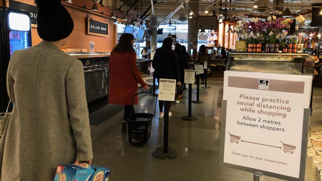 Des gens font la file pour payer dans un supermarché.