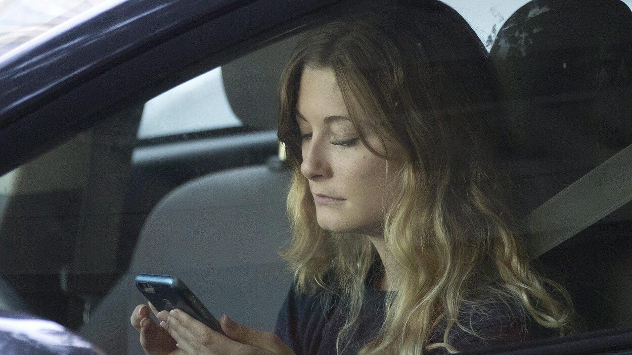 Une automobiliste consulte son téléphone. Une automobiliste consulte son téléphone.