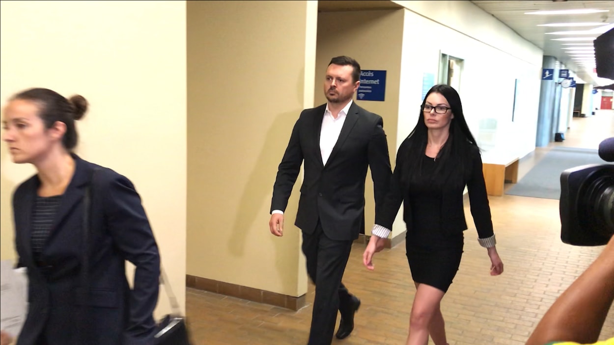 Dominic Lacroix et sa conjointe marchent dans les couloirs du palais de justice de Québec.