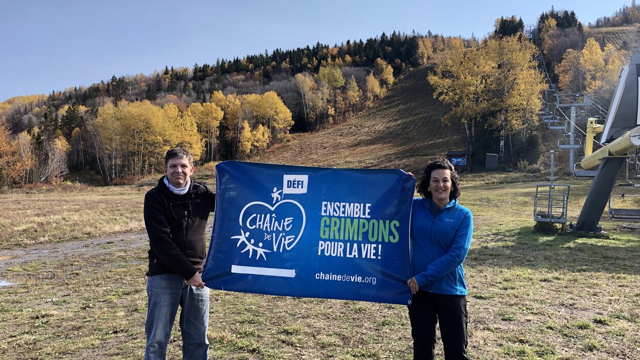 Au pied de la montagne, ils tiennent la bannière du Défi Chaîne de vie.