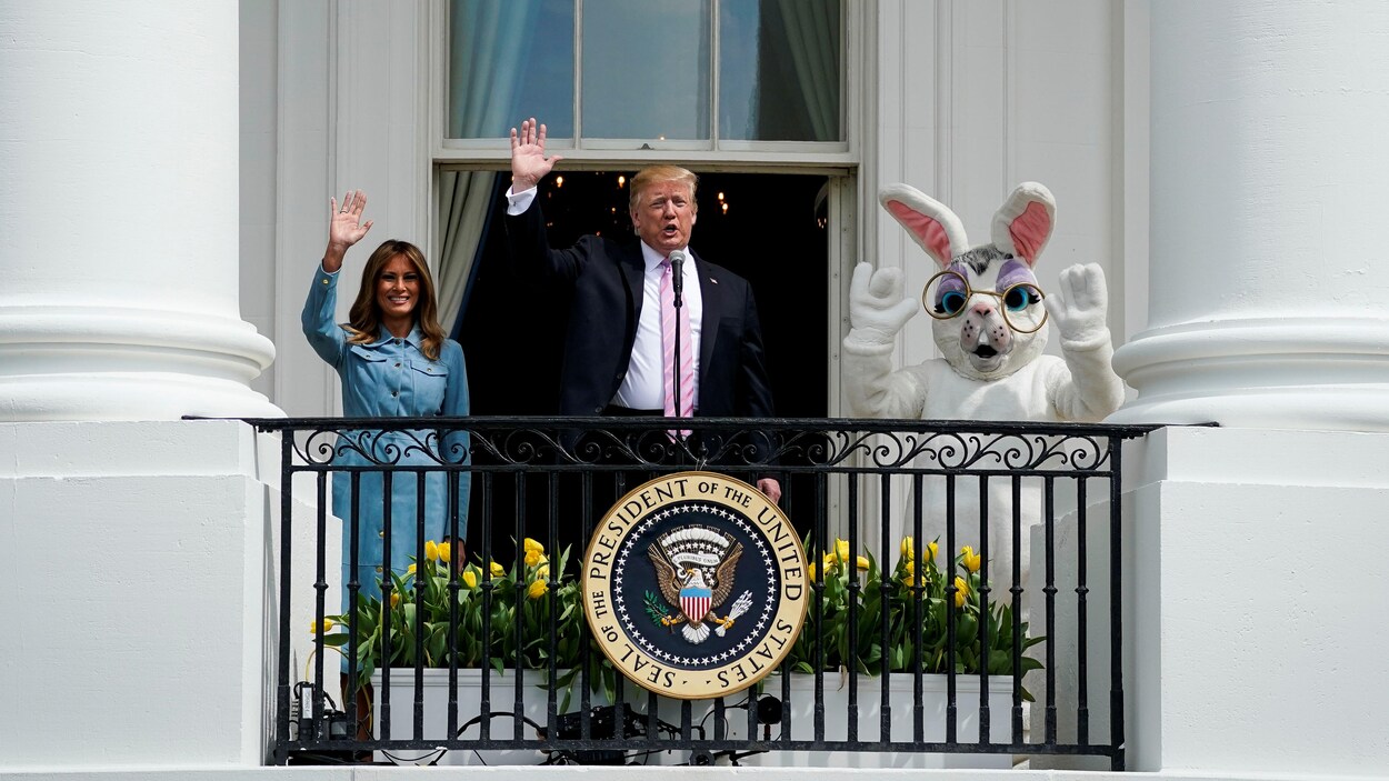 Le couple présidentiel, accompagné d'un individu portant un costume de lapin, salue vers la caméra.