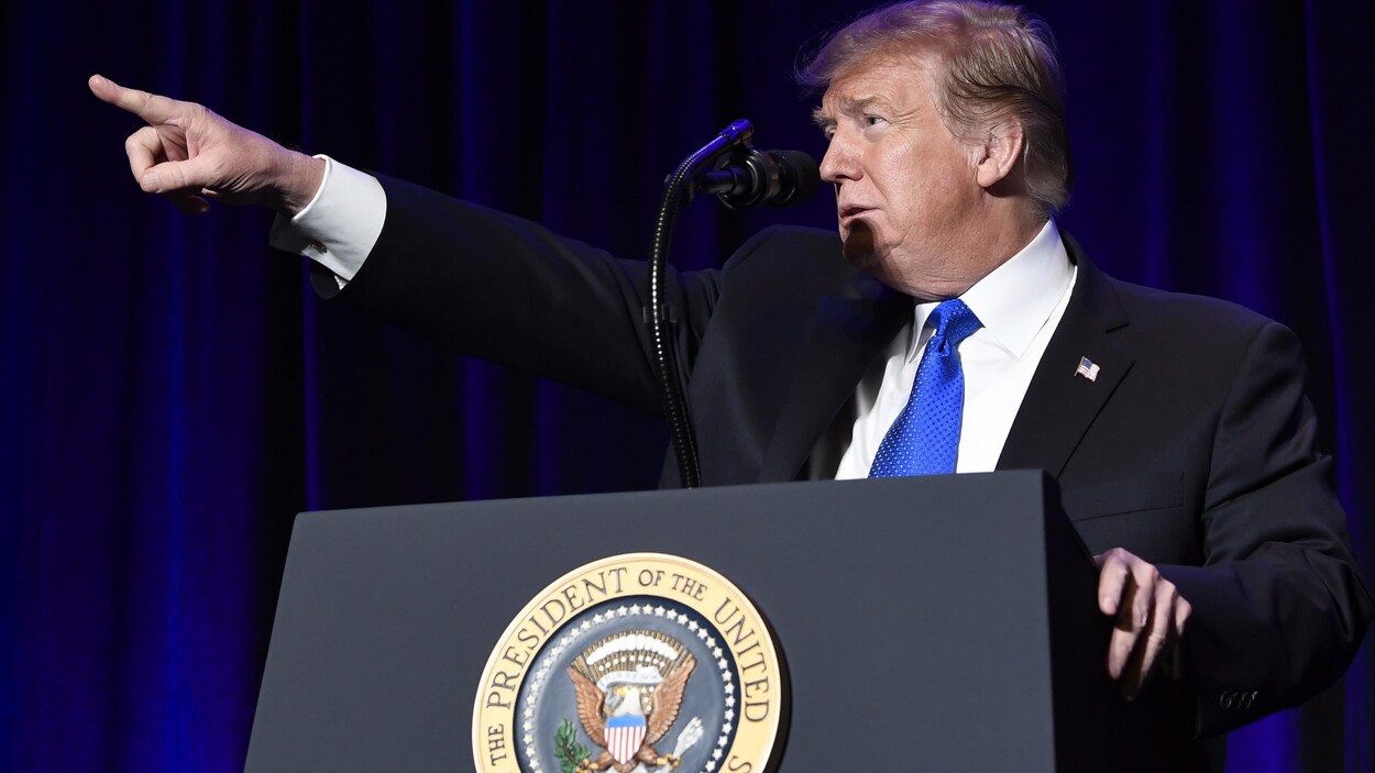 Le président américain Donald Trump, qui pointe au loin.
