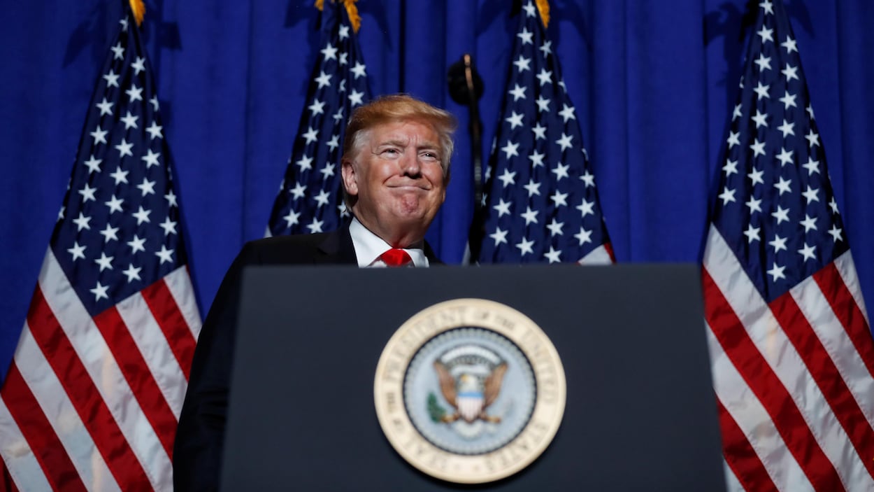 Donald Trump devant des drapeaux américains