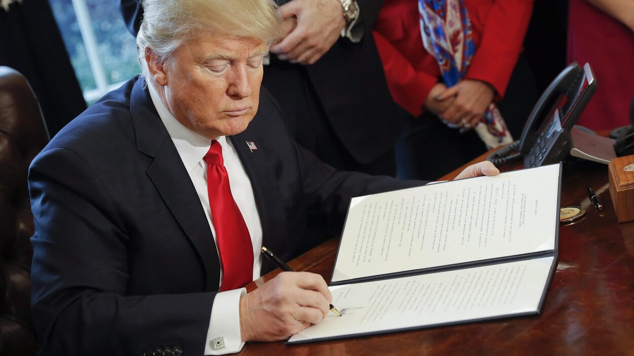Le président américain, Donald Trump, appose sa signature au bas d'un décret présidentiel à la Maison-Blanche.