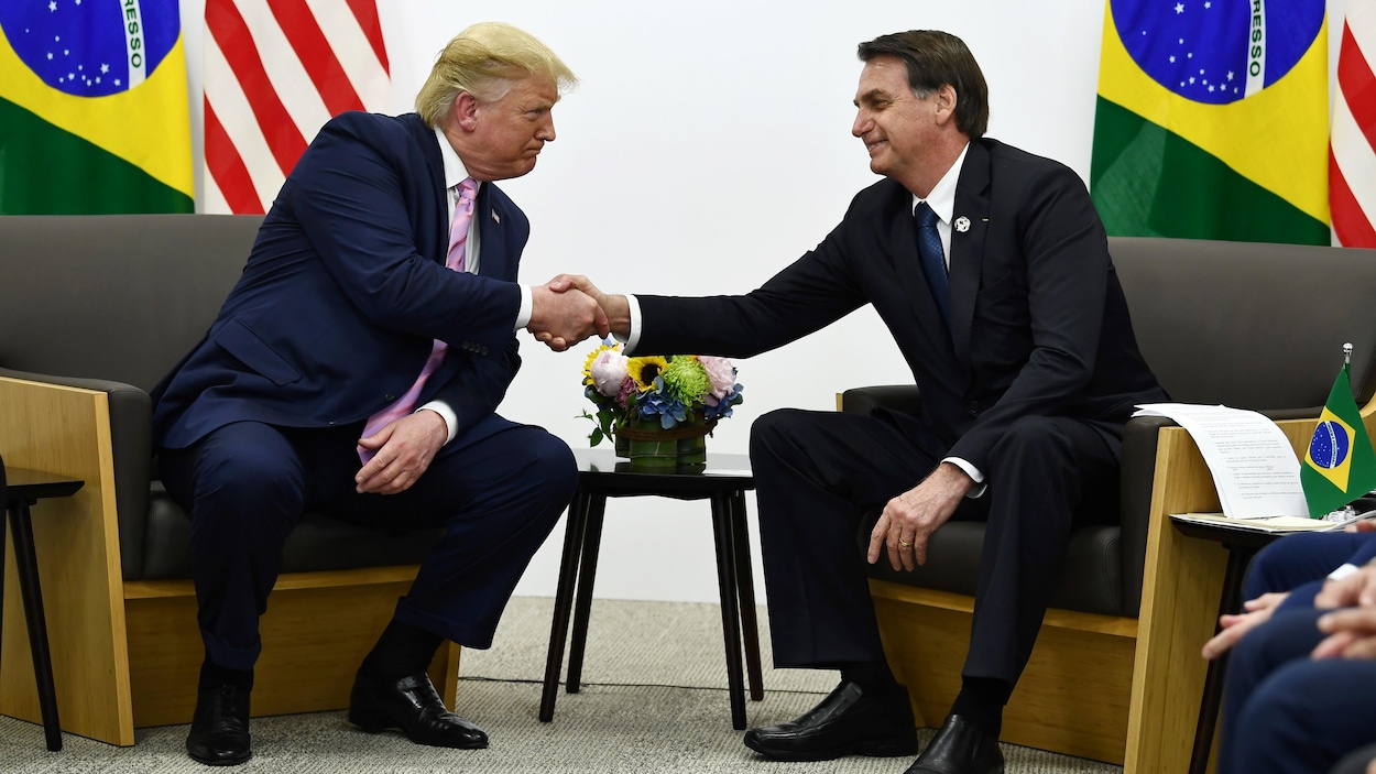 Donald Trump et Jair Bolsonaro échangent une poignée de main.