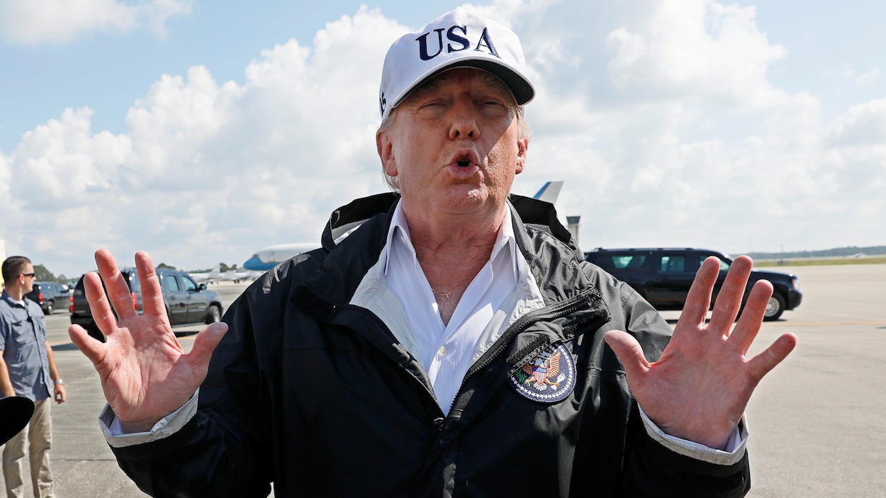 Donald Trump porte une grande casquette blanche, où il est inscrit "USA". Il se trouve sur le tarmac d'un aéroport à Fort Myers, en Floride. Donald Trump porte une grande casquette blanche, où il est inscrit "USA". Il se trouve sur le tarmac d'un aéroport à Fort Myers, en Floride.