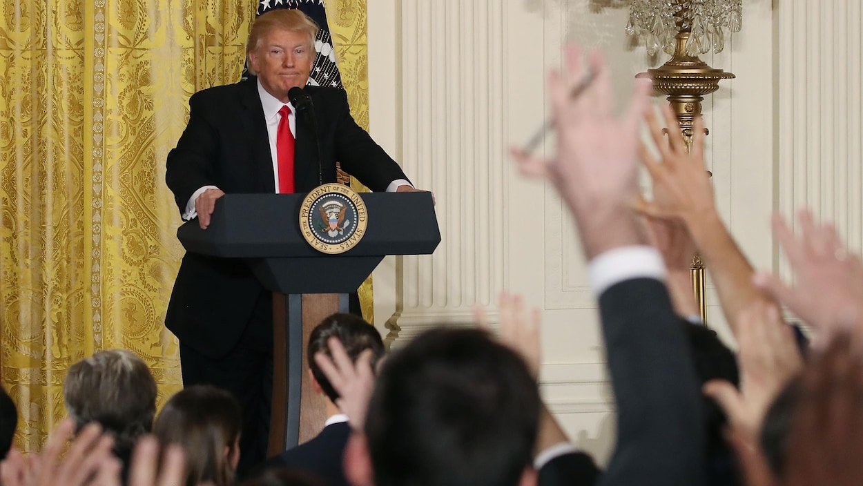 Des journalistes lèvent leurs mains pour poser des questions au président