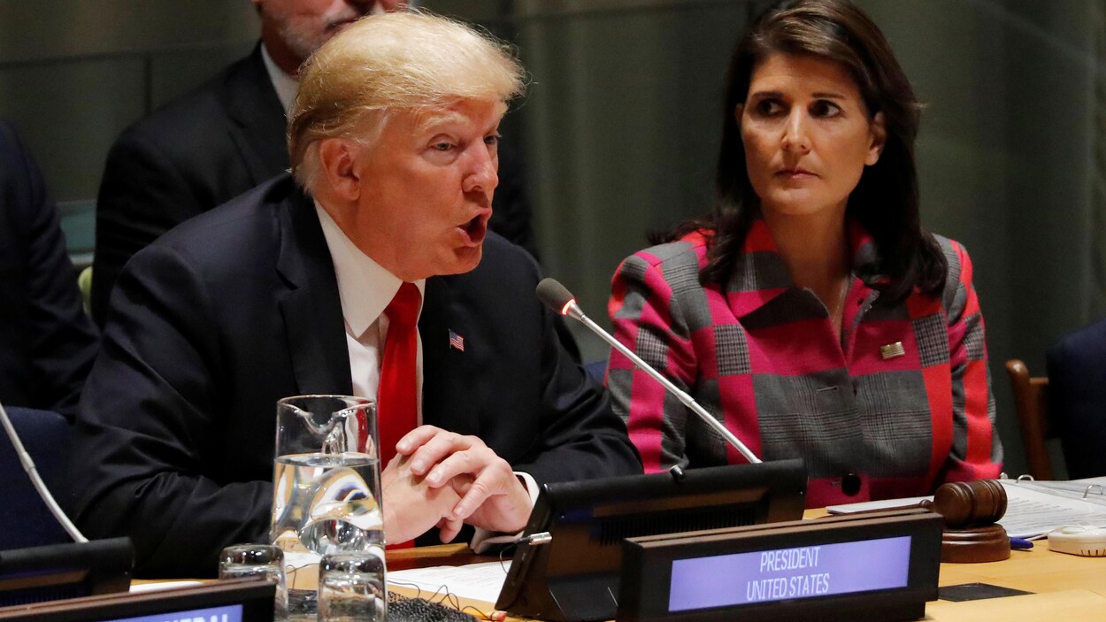 Donald Trump est assis et parle au micro.