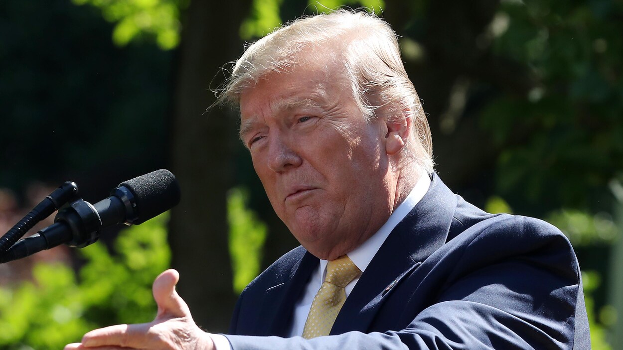 Le président Donald Trump parle au micro dans un jardin.