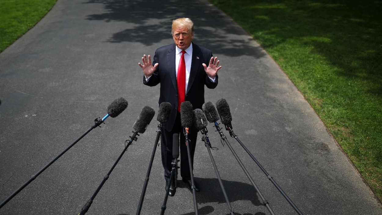 Le président américain Donald Trump debout en conférence de presse, devant des micros tendus vers lui. Le président américain Donald Trump debout en conférence de presse, devant des micros tendus vers lui.