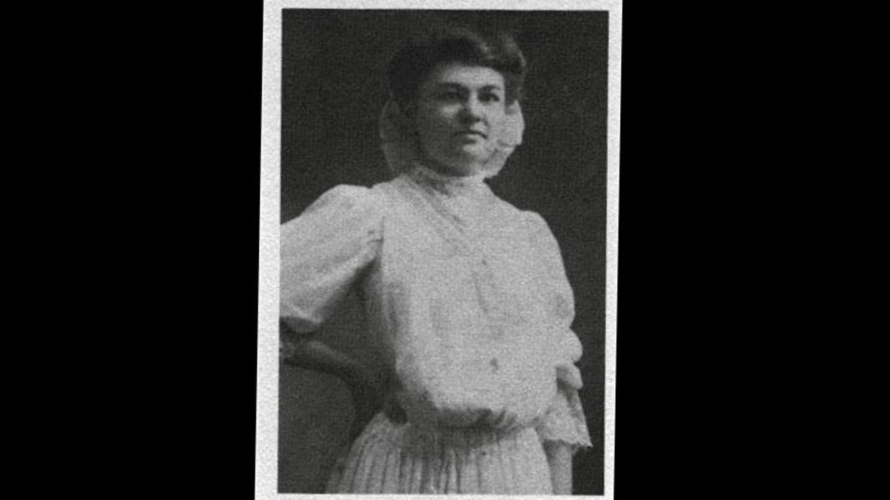 Photographie en noir et blanc de Donalda Charron, posant en robe claire à la caméra.