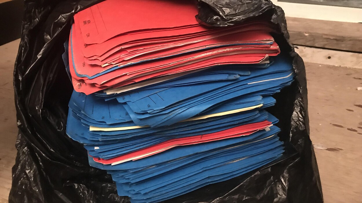 Des dossiers dans un sac à ordure.