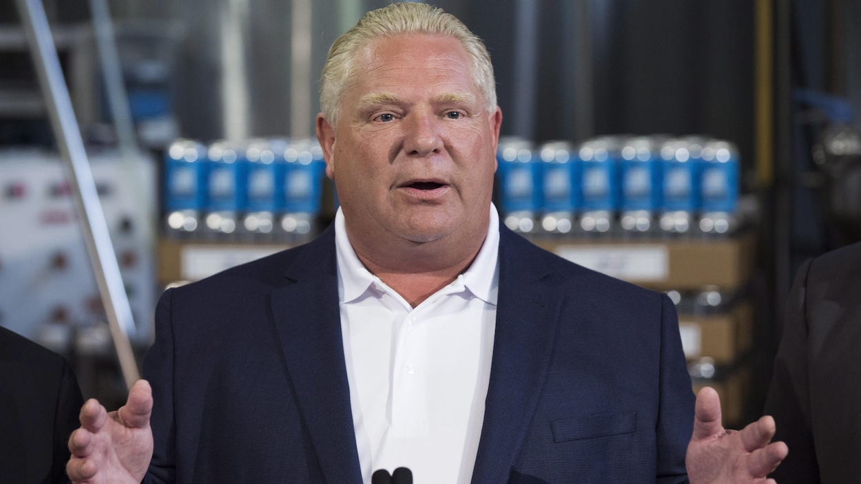 M. Ford en complet devant des canettes de bière.